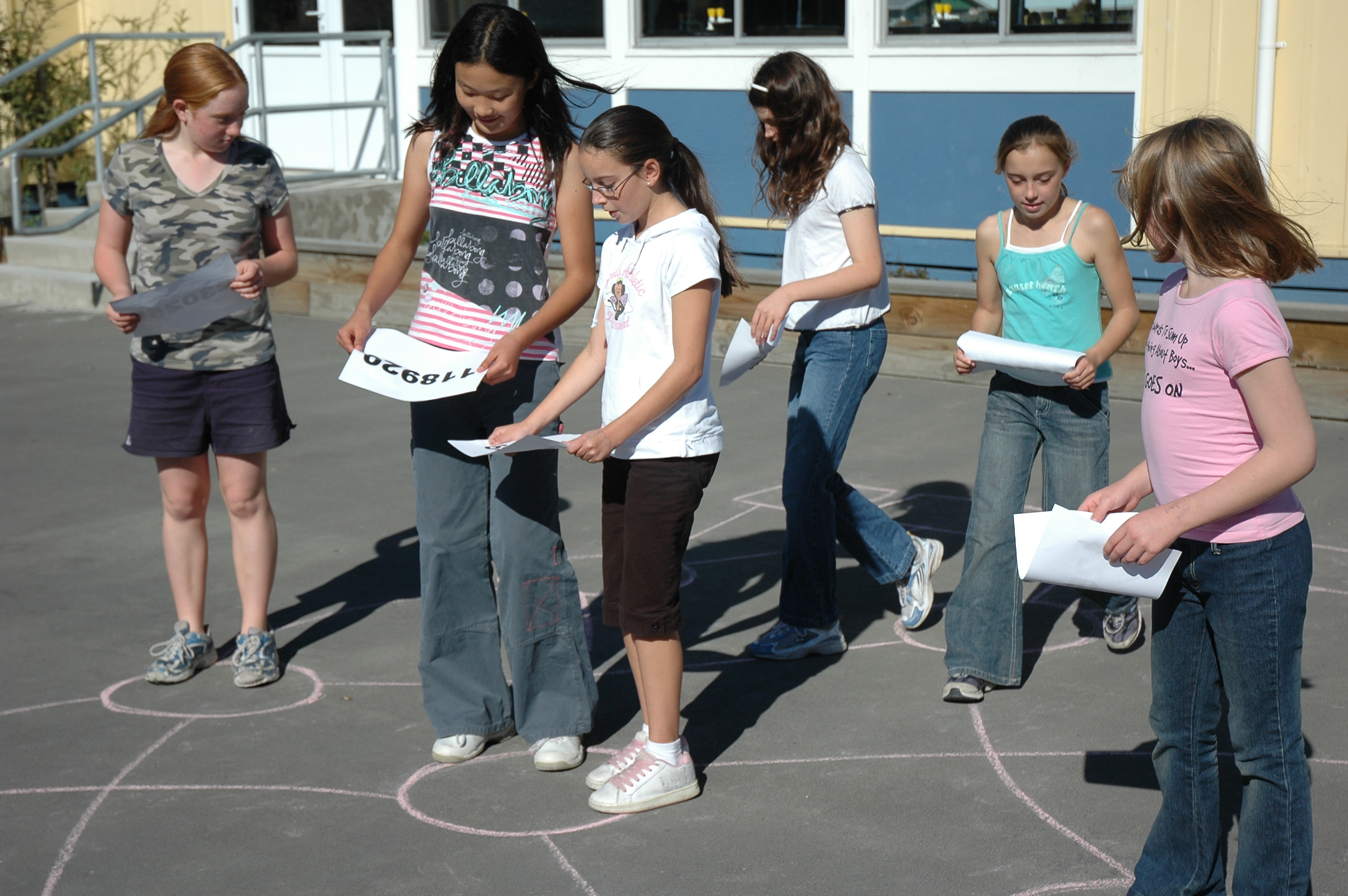 A group of young kids solving a puzzle in an outdoor environment